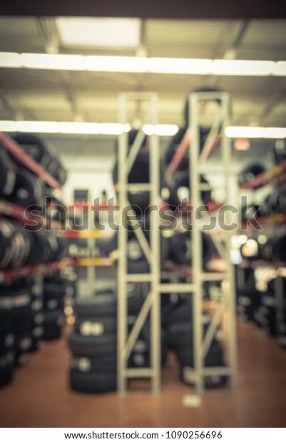 Vintage blurred rows of brand new tires for sale\
at auto care center retail store in USA. Defocused background of\
industrial repair\
services
