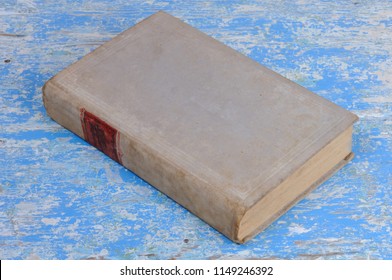 Vintage Book In Gray Binding On A Blue Background. View From Above.