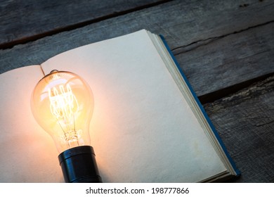 Vintage Book And Light Bulb On Wood Table