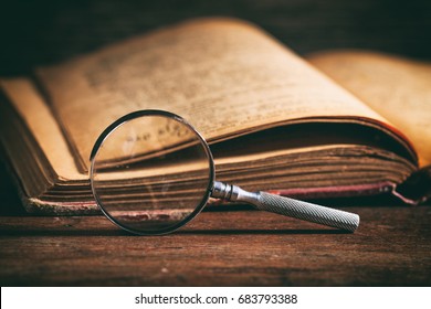 Vintage book and magnifying glass on wooden background
 - Powered by Shutterstock