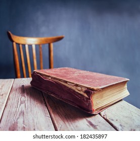 Vintage book on a wooden table in a classroom