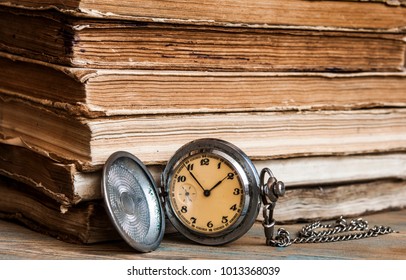 Vintage books and pocket watch on a wooden desk  - Shutterstock ID 1013368039