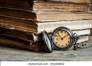 Vintage books and pocket watch on a wooden desk  - Shutterstock ID 1013368042