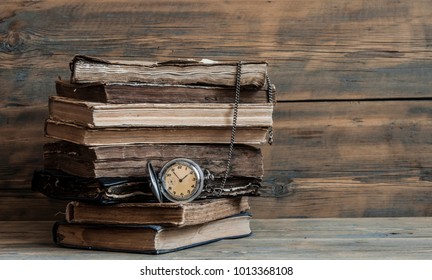 Vintage books and pocket watch on a wooden desk  - Shutterstock ID 1013368108