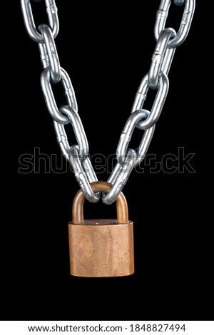 A vintage brass lock connecting a thick, chrome chain isolated on black.