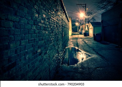 Vintage Brick Wall In A Dark, Gritty And Wet Chicago Alley At Night After Rain.