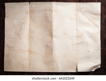 Vintage broken empty folded and crumpled paper on dark wooden table