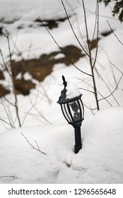 Vintage Broken Lamp-post Light Fixture In The Winter Snow