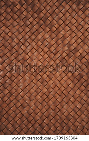 Vintage brown braided leather texture. Leather woven together. Abstract clothing background. Natural material. Vertical photo.