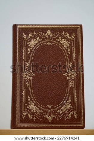 Vintage brown cover of book with decorative golden details and tendrils