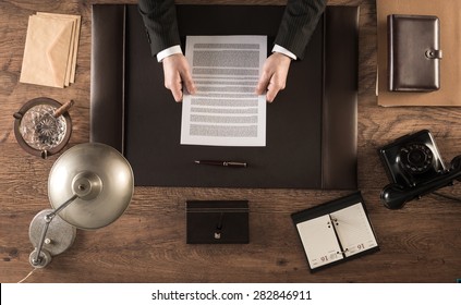 Vintage Businessman In The Office Reading A Contract Sitting At His Desk, Top View