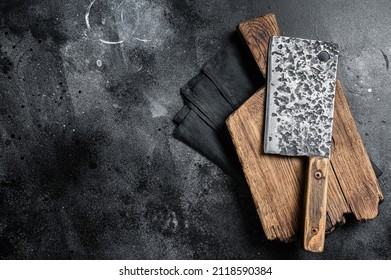 Vintage butcher meat cleaver with cloth towel. Black background. Top view. Copy space