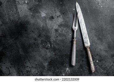 Vintage Butcher Meat Fork And Knife With Cloth Towel On Wooden Table. Black Background. Top View. Copy Space.