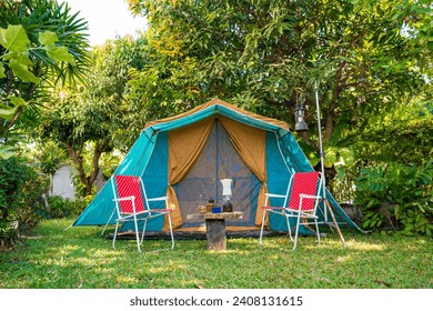 vintage cabin tent,  Antique oil lamp, retro chairs, Group of camping tents with outdoor coffee-making facilities on wooden tables in a forest camping area in the forest. - Powered by Shutterstock