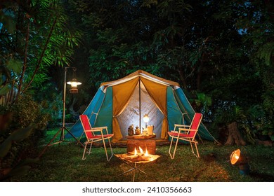 vintage cabin tent,  Antique oil lamp, retro chairs, Group of camping tents with outdoor coffee-making facilities on wooden tables in a forest camping area in the forest.