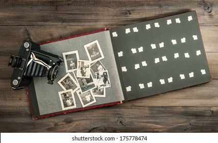 Vintage Camera And Album With Old Family Photos On Wooden Table. Retro Style Picture