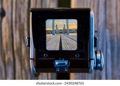 Vintage Camera Framing Dock and Cityscape at Sunset - Powered by Shutterstock