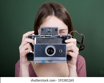 Vintage camera in hand on green