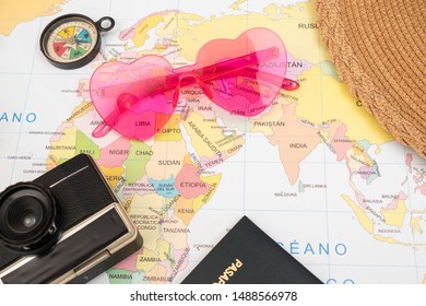 Vintage camera, pink sunglasses, passport, hat and compass on a map as background - Shutterstock ID 1488566978