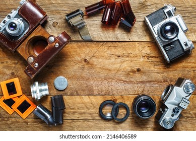 vintage cameras and lenses on the background of old boards. View from above. Place for text.