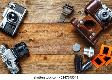 vintage cameras and lenses on the background of old boards. View from above. Place for text.