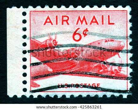 Vintage cancelled USA airmail postage stamp showing an red image of a cargo aeroplane