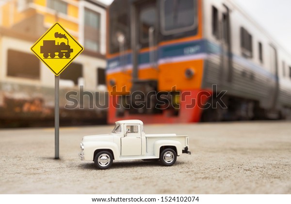 Vintage car and alarm sign of Railway crossing\
without gates ,traffic\
sign