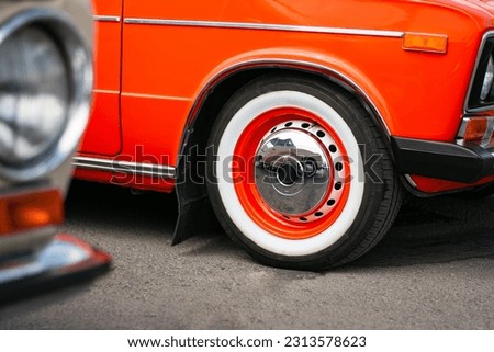 Vintage car with chrome rims, and whitewalls tires. 