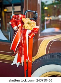 Vintage car decorated with a red bow for the wedding ceremony.