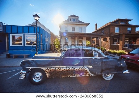 Vintage Car with Leopard Accents on Small Town Street, Lens Flare Effect