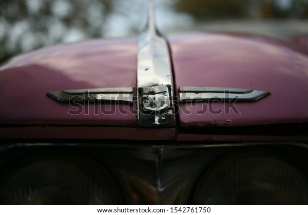 Vintage car sat in the\
Cuban sun, showing off it\'s aged/patina styles. Lovely detail in\
pink colors, and depth of field. Perfect transportation for a Cuban\
holiday