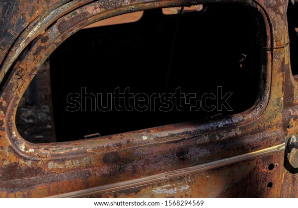 Vintage car window frame with peeling paint,\
rust and texture, offering a site for text inside the window,\
abstract setting.