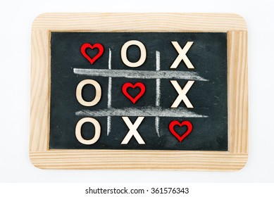 Vintage Chalkboard With Tic Tac Toe Game Competition XO Win Created Of Wood Letters And Red Hearts, Letters O And X Replaced With Red Heart Shapes, Isolated On White, Love Always Wins Concept 