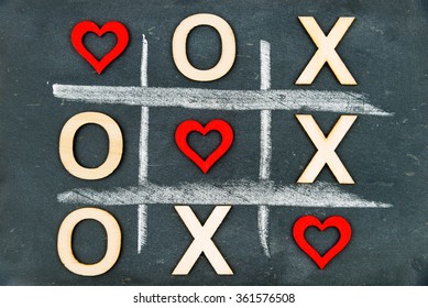 Vintage Chalkboard With Tic Tac Toe Game Competition XO Win Created Of Wood Letters And Red Hearts, Letters O And X Replaced With Red Heart Shapes, Challenge And Love Always Wins Concept 