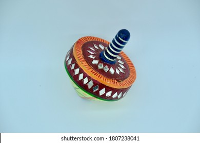 Vintage Child's Spinning Top Toy In Studio Image On White Background With Green, Red, Blue And White Paint And Little Symmetric Mirrors