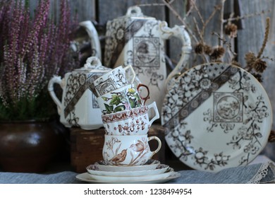 Vintage China, Porcelain Tea Cups on Saucer, Branches with Cones, Heather in Clay, Ceramic Pot, Antique Coffeepot, Sugar Bowl, Plate on Aged Wooden Background, Rustic Style