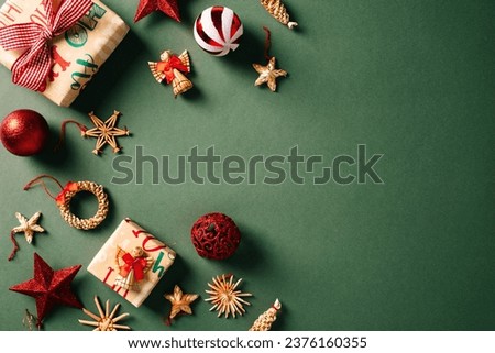 Vintage Christmas background with red and white balls decorations, handicraft Xmas ornaments, craft paper gift boxes on green table. Retro Christmas card template.