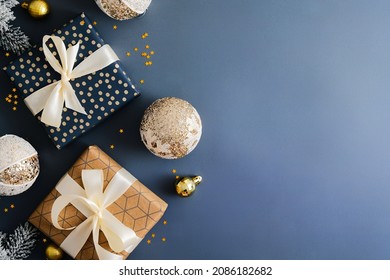 Vintage Christmas greeting card design with gift boxes and retro baubles on dark blue background. Flat lay, top view, copy space.