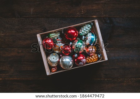 Vintage Christmas ornaments, antique retro Christmas glass baubles, balls in wooden box on rustic background. Old xmas decoration for Christmas tree in gif box