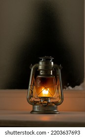 Vintage Christmas Shining Oil Lantern Over Frozen And Snowy Window. Christmas, Tradition And Celebration Concept.