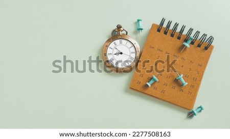 vintage clock and grunge brown calendar, green thumbtack on grunge green background with copy space, business meeting schedule, travel planning or project milestone and reminder  concept
