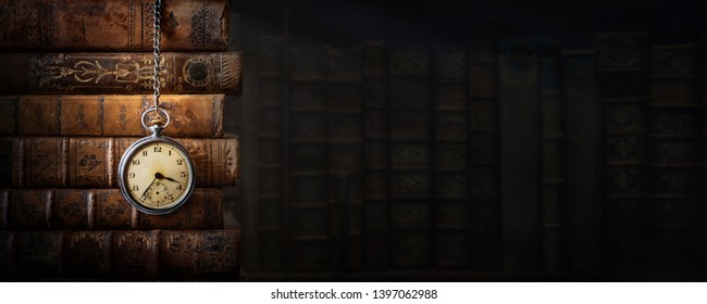 Vintage clock hanging on a chain on the background of old books. Old watch as a symbol of passing time. Concept on the theme of history, nostalgia, old age. Retro style. - Shutterstock ID 1397062988