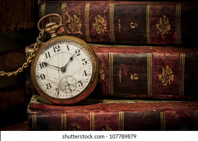 Vintage clock and old books in the background. Still life in Low-key, copy space. Concept of vinage, time,the past, or deadline.