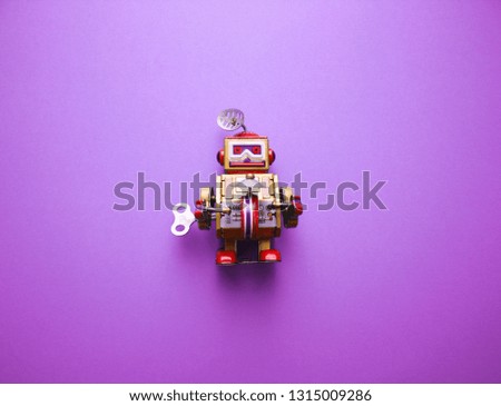 Vintage clockwork metal toy robot on the purple background. Retro toys minimal concept. Flat lay. Top view.