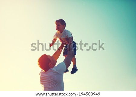 Vintage color photo happy joyful father having fun throws up in the air little boy child, family, travel, vacation, father's day - concept. Sunlight on the sunset background