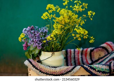 Vintage Colorful Handmade Rug And Spring Flowers In Watering Can. Country Life,cottage Core, Creative Rustic Patchwork Concept. Copy Space.