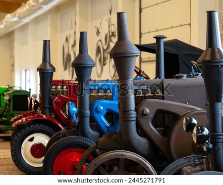 Vintage, colorful tractors in the museum. Agricultural machinery used in land cultivation. The beginnings of agricultural mechanization