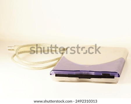Vintage computer technology: external 3.5 inch USB-A floppy disk drive (FDD) in apple design with silver cable