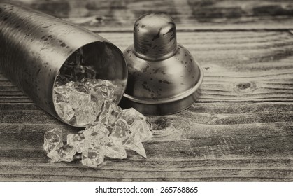 Vintage Concept Of An Old Metal Drink Mixer Lying On Side With Crushed Ice Spilling Out Onto Rustic Wood