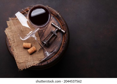 Vintage corkscrew and red wine glasses on old wooden wine barrel. Top view flat lay with copy space - Powered by Shutterstock